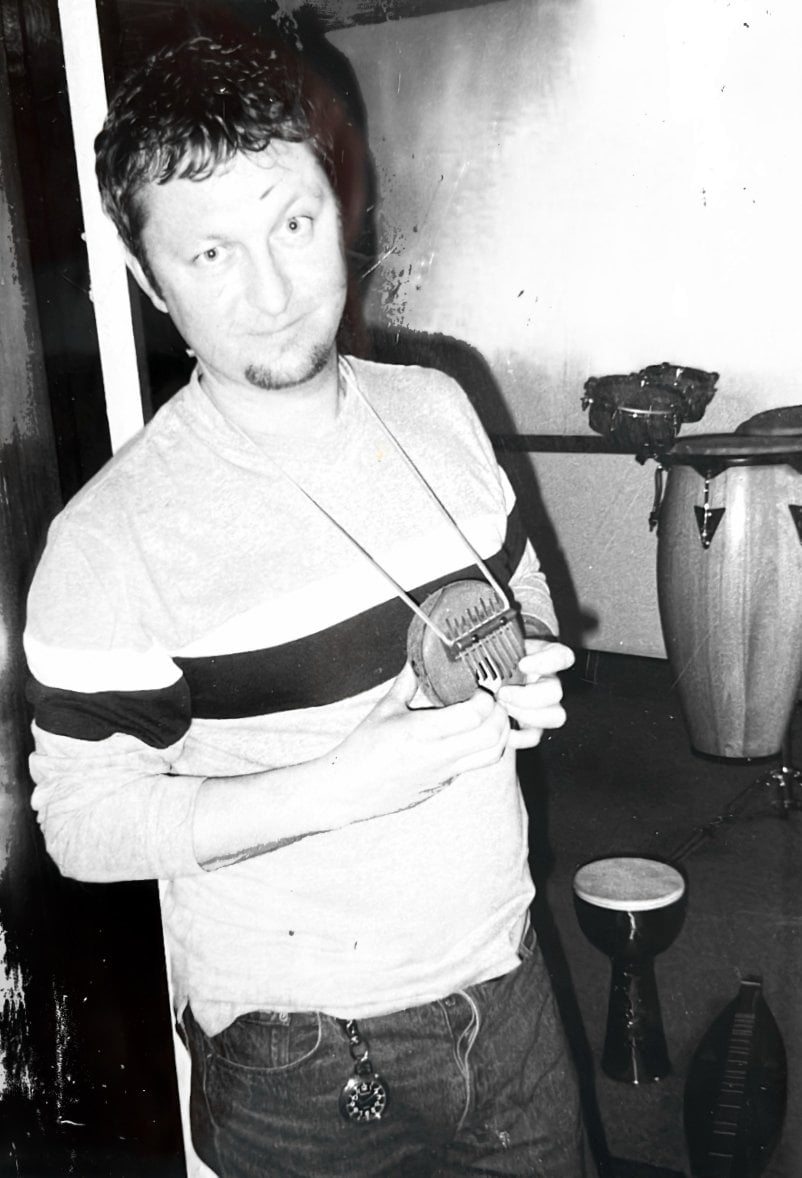 Dave Allen poses with a small thumb piano in his hands, at Eighth Dimension Studio in Orlando, Florida, 1998