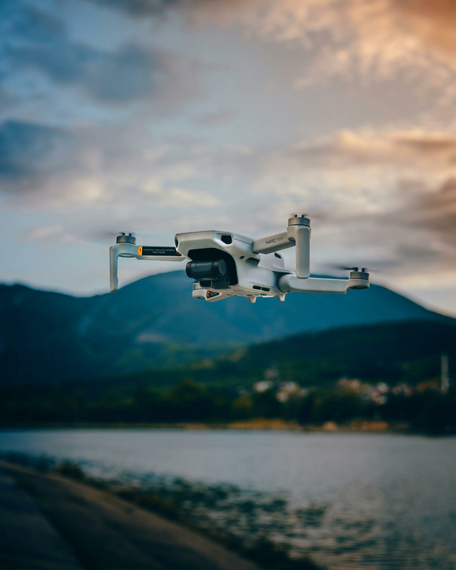 Flying UAV UAV flying over a lake with a mountain in the backdrop.
