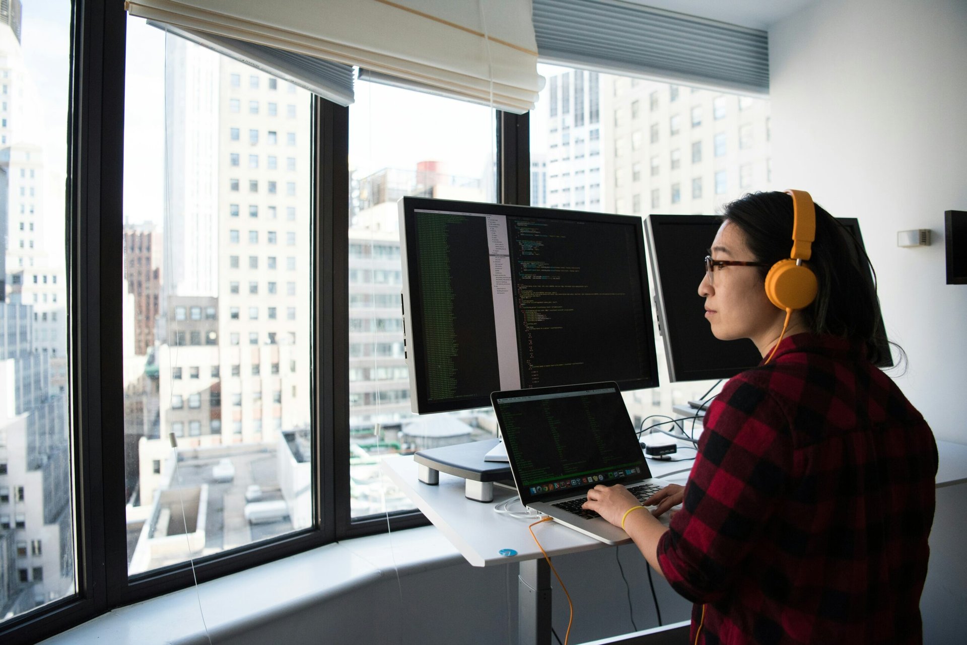 Software engineer working Software engineer coding in front of a skyline view.
