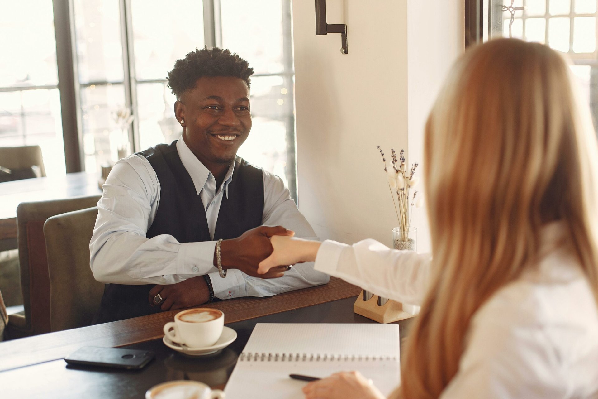 pexels-gustavo-fring-3874034 Two professionals shaking hands across a table.