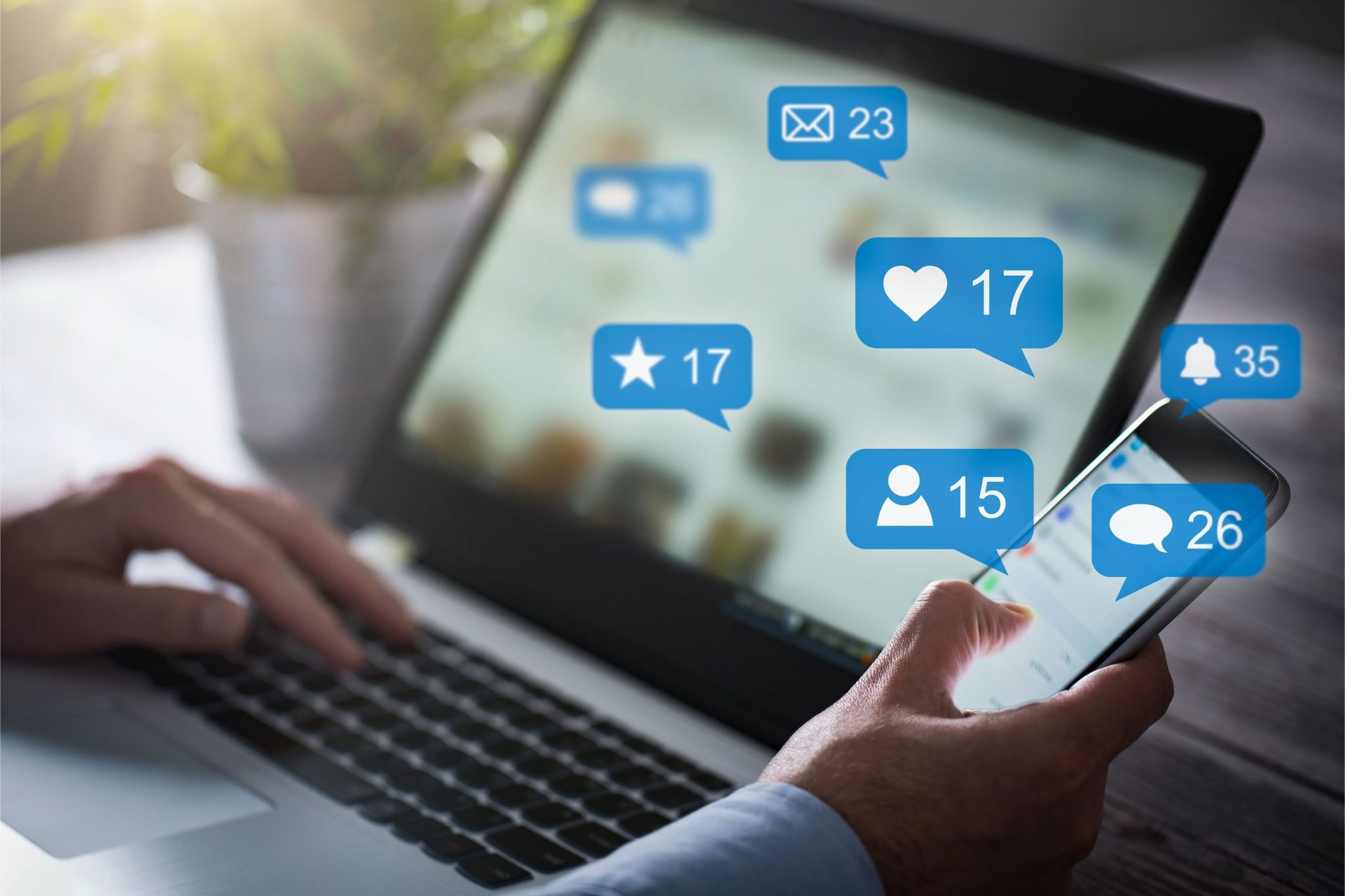 A person using a laptop with social icons on it.