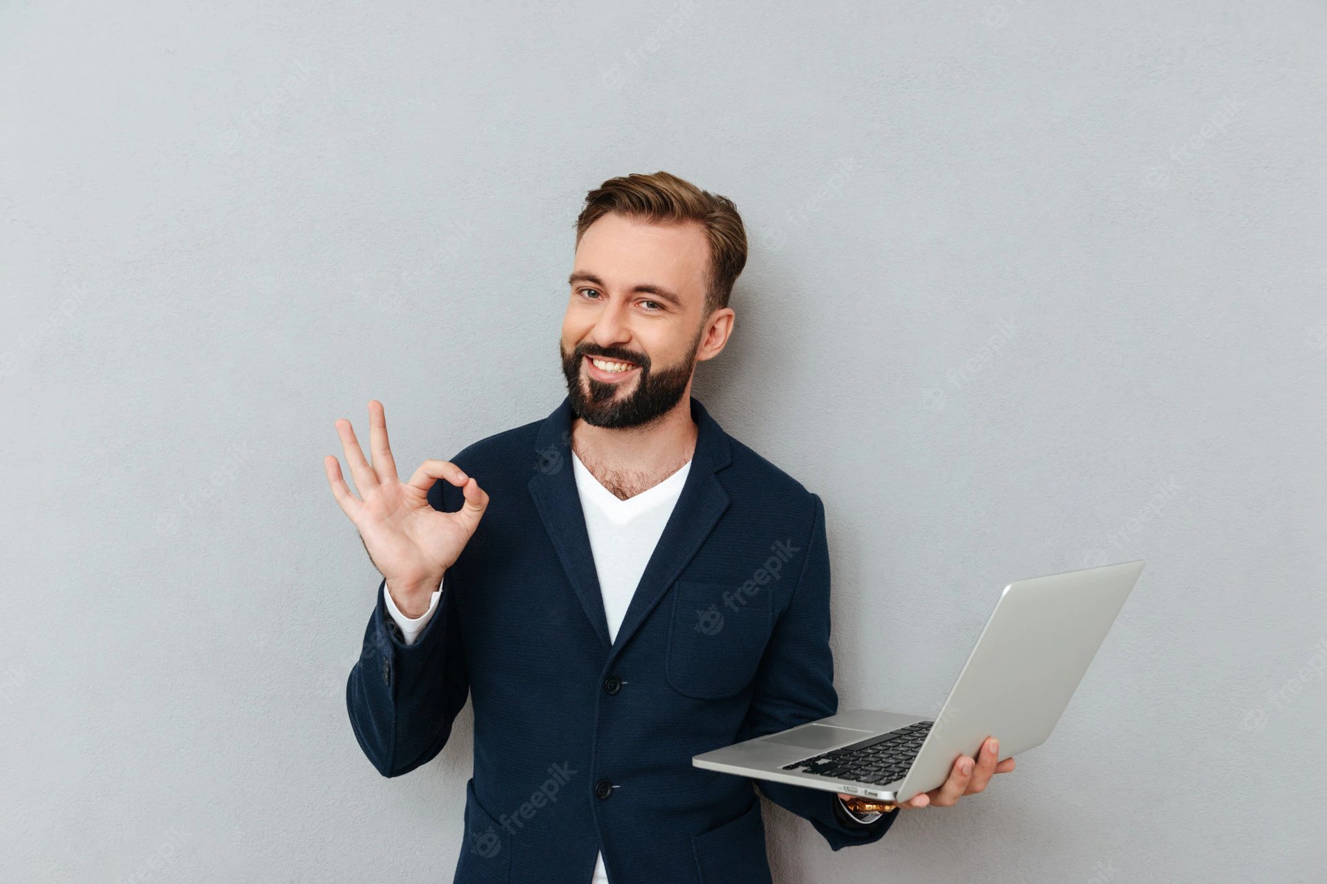 young-bearded-man-suit-looking-camera-while-holding-laptop-computer-isolated_171337-11341 img-4
