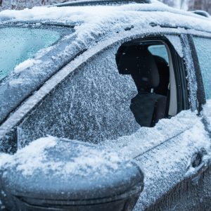 frozen car after snowstorm with broken window Frozen car with a broken window covered in snow and ice, highlighting the need for auto glass repair services in cold weather conditions.