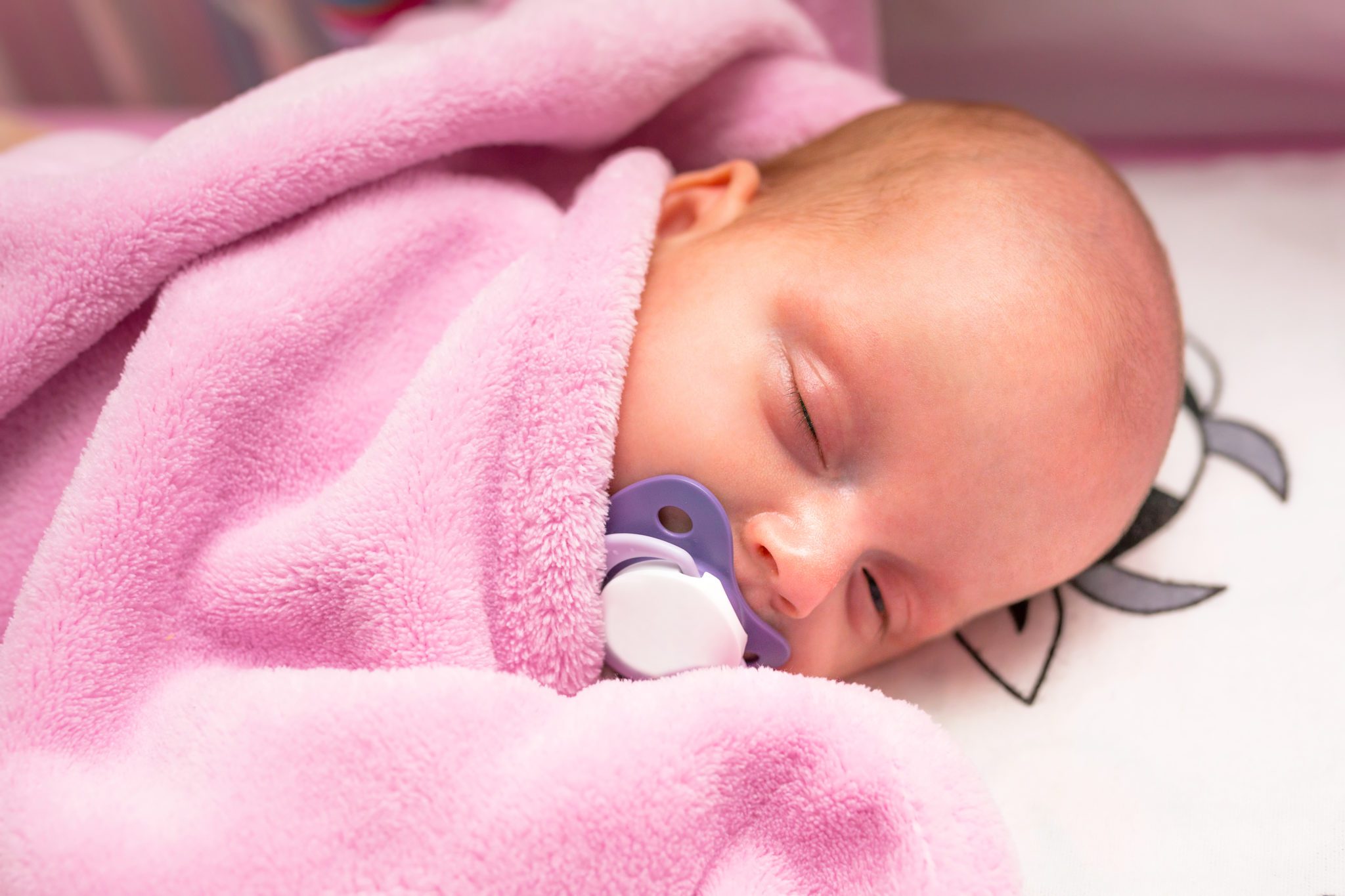 Pink baby blanket with baby.