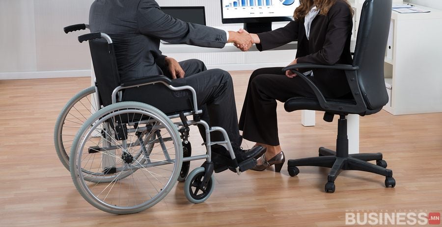 Тэргэнцэртэй бизнес эрхлэгч, оффисын сандал дээр суугаа өөр хүн мэргэжлийн орчинд гар барина. - Business.MN