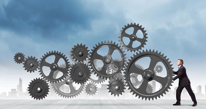 Костюм өмссөн хүн дээвэр дээр зогсож, том араа түлхэж байна. Янз бүрийн хэмжээтэй олон араа хоорондоо холбогдож, тэнгэрт хөвж, цаана нь хотын дүр төрх харагдаж байна. Энэ үзэгдэл нь хамтын ажиллагаа, аж үйлдвэрийг бэлэгддэг. - Business.MN