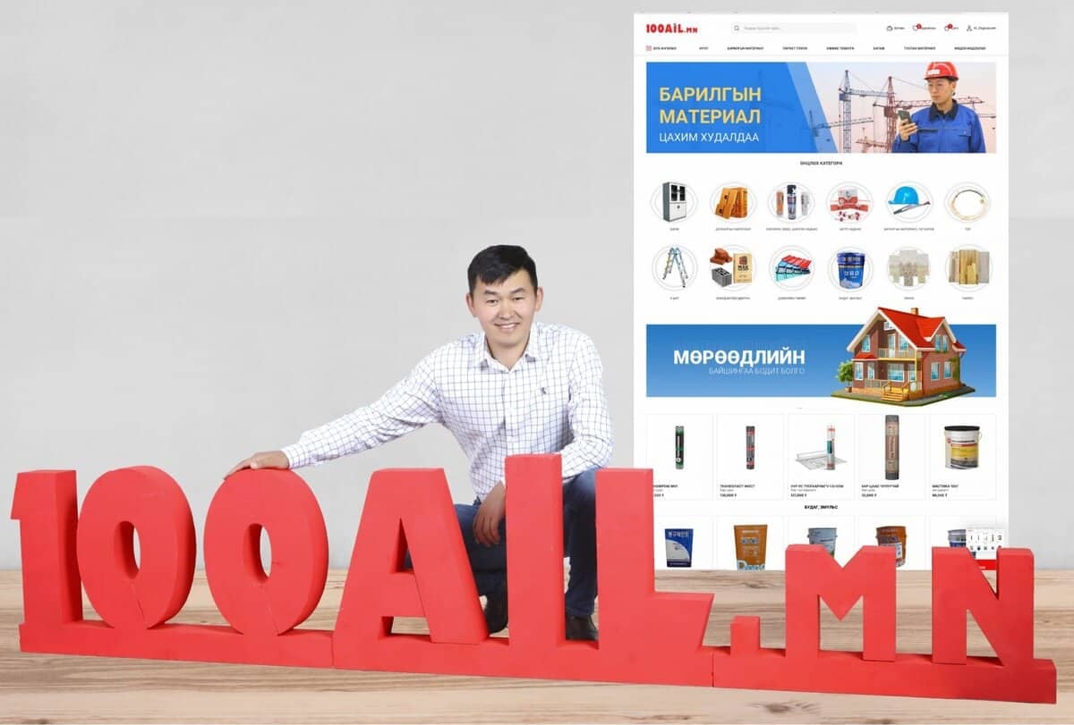 "100AIL.mn" гэж бичсэн том улаан үсгүүдийн хажууд алаг цамцтай эр тонгойж байна. Түүний ард янз бүрийн барилгын материал, багаж хэрэгслийг харуулсан том зурагт хуудас, бүтээгдэхүүний зураг, вэб хуудасны интерфэйс нь компанийнхаа өргөлийг сурталчлахад түүний энтрепренер сэтгэлгээг харуулсан байна. - Business.MN