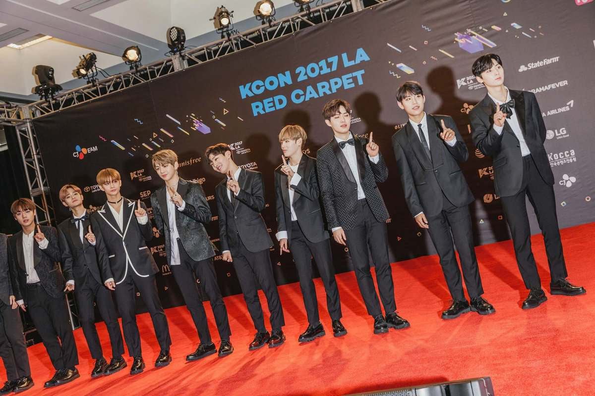 11 хүний бүрэлдэхүүнтэй хослол өмссөн хүмүүс KCON 2017 LA-гийн улаан хивсний ёслол дээр зогсож, К-поп урлагийн өнгө аясыг харуулсан. Тэд янз бүрийн логогоор чимэглэсэн арын дэвсгэрийн өмнө энх тайвны тэмдгүүдийн хамт зургаа авахуулж, К-поп соёлын мөн чанарыг харуулсан бөгөөд энэ нь хувьцаа худалдаж авахтай адил түгээмэл болж байгаа зохистой хөрөнгө оруулалт юм. - Business.MN