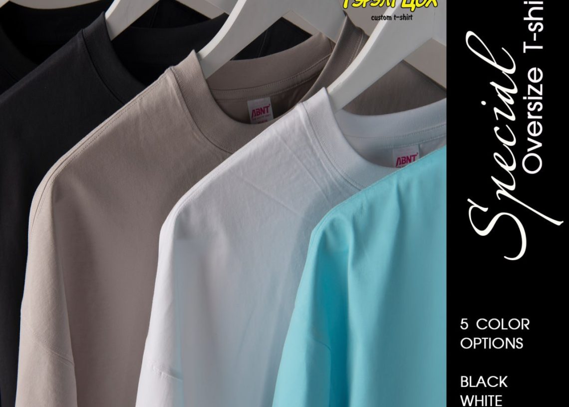 Шаргал, хар, цагаан, цайвар цэнхэр өнгийн дөрвөн том цамц цагаан өлгүүрт өлгөөтэй байна. Текст "Тусгай том хэмжээтэй футболк"-ыг онцолж, хар, цагаан, нүүрс, шаргал, цэнхэр гэсэн таван өнгөний сонголтыг жагсаав. - Business.MN