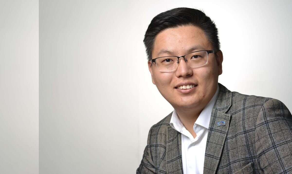 Нүдний шил, алаг пиджак өмссөн хүн амжилттай энтрепренер мэт харагдах бөгөөд энгийн дэвсгэр дээр камер руу инээмсэглэнэ. - Business.MN