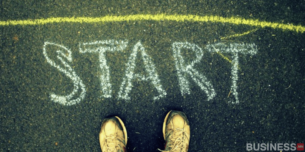 "START" гэж шохойгоор бичсэн асфальтан дээр өмссөн өмссөн гүйлтийн гутлын ойрын зураг нь энтрепренерийн цэцэглэн хөгжиж буй компани байгуулах аялалын эхний алхмуудыг бэлэгддэг. - Business.MN