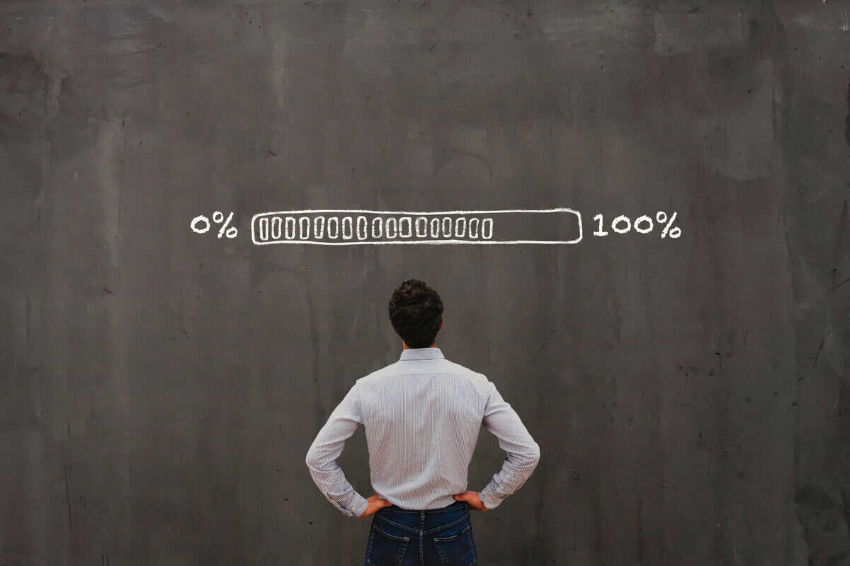 Энтрепренер шохойгоор зурсан явцын самбар бүхий том самбарын өмнө зогсож байна. Явцын тал нь зүүн талд 0% -аас баруун талд 100% хүртэл үргэлжилдэг бөгөөд энэ нь бизнесийн ахиц дэвшил эсвэл дууссаныг бэлэгддэг. Тэр хүн гараа ташаан дээрээ барьж, компанийнхаа замыг эргэцүүлэн ажиглана. - Business.MN