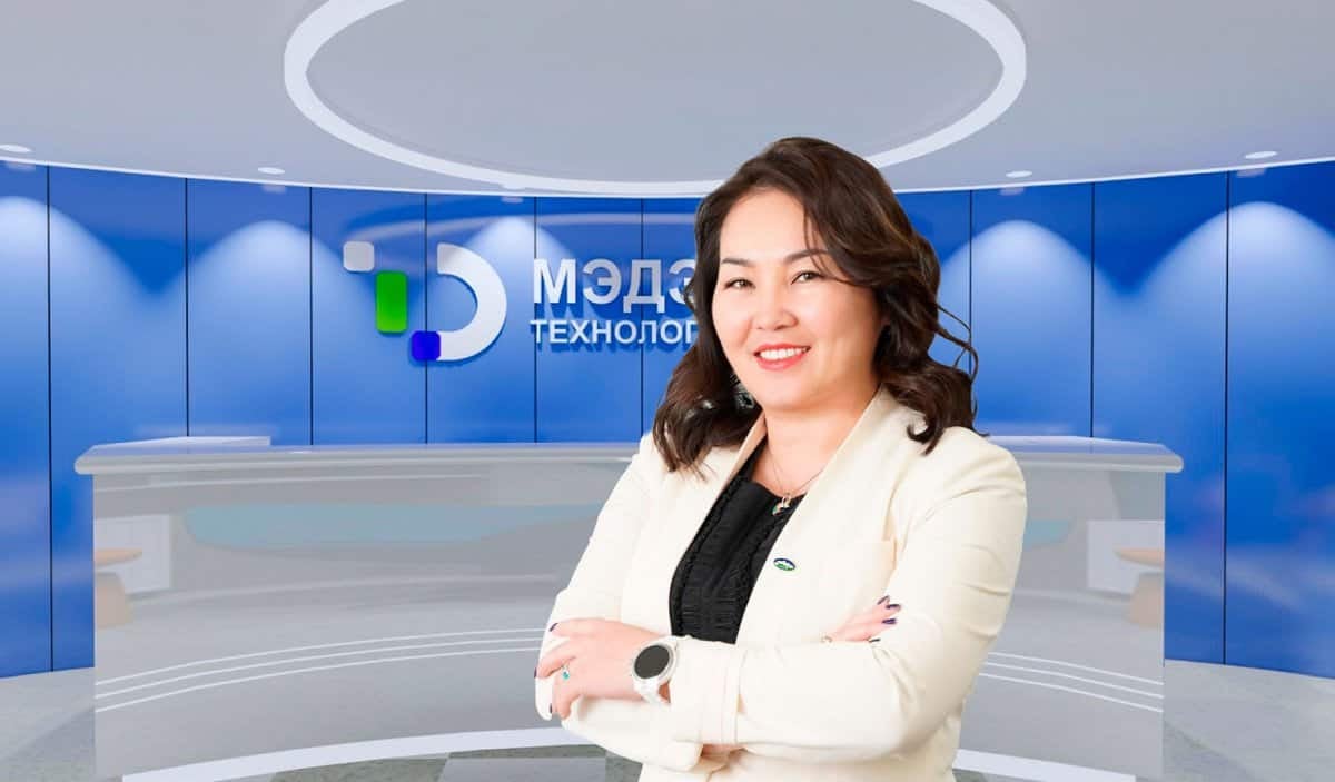 Хар үстэй эмэгтэй инээмсэглэн, орчин үеийн хүлээн авалтын өрөөний өмнө гараа зөрүүлэн зогсож байна. Тэр хөнгөн пиджак өмссөн байна. Түүний ард, лого бүхий цэнхэр хананд "МЭДЭ ТЕХНОЛОГИ" гэсэн бичээс тод харагдах бөгөөд энэ нь түүний энэ шинэлэг компанид бизнес эрхлэгчийн үүргийг харуулж байна. - Business.MN