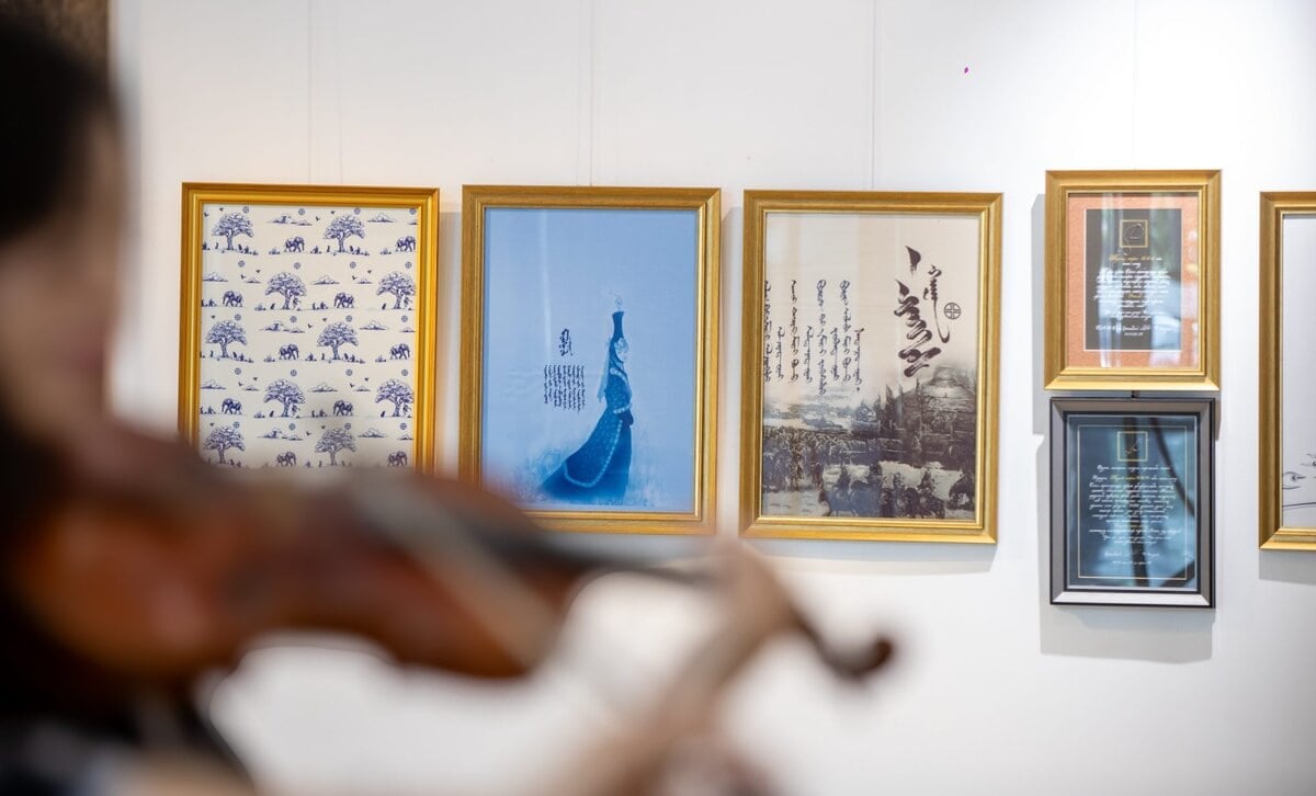 Бүдгэрсэн дүрс урд талд хийл тоглож, цагаан хананд таван жаазтай урлагийн бүтээл, уран бичлэгийг харуулсан байна. Төрөл бүрийн хэв маяг, сэдвийг агуулсан урлагт анхаарлаа хандуулдаг. - Business.MN