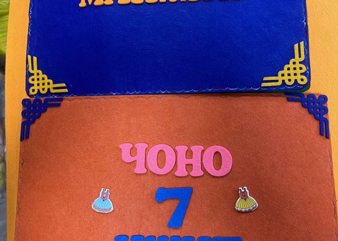 A colorful display featuring two rectangular items with decorative borders. The top item is blue with orange letters, and the bottom item is orange with pink and blue letters and small decorative elements.