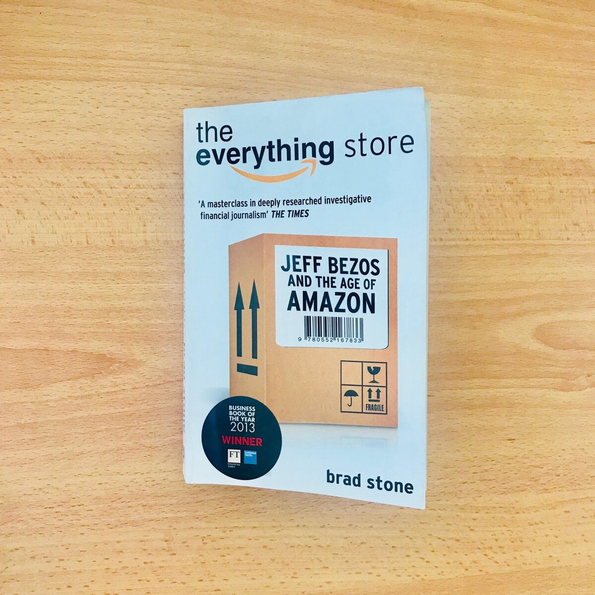 Брэд Стоуны "The Everything Store" номын хавтас. Хавтас нь "Жефф Безос ба Амазоны эрин үе" гэсэн бичвэр бүхий картон хайрцагны загвартай. Үүнд 2013 оны шилдэг бизнесийн номны шагналын наалт багтсан. - Business.MN