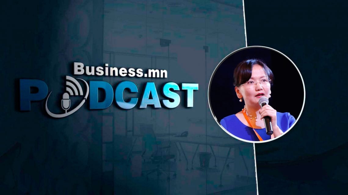 "Business.mn Podcast" гэсэн бичвэр бүхий подкаст ковер зураг болон микрофонд ярьж буй энтрепренерийн дугуй зураг. Арын дэвсгэр нь бараан бүдэг оффисын тохиргоотой. - Business.MN