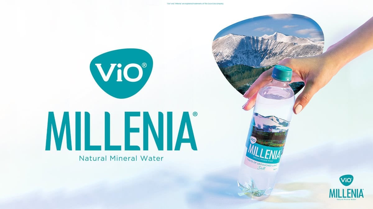 Эх байгалийн амтыг шингээсэн Vio Millenia байгалийн рашаантай савыг гартаа атгав. Арын дэвсгэр нь зүрхэн хэлбэртэй уулын үзэмжийг харуулдаг. Уг бичвэрт Vio логоны хажууд "Vio Millenia байгалийн эрдэст ус" гэж бичжээ. - Business.MN