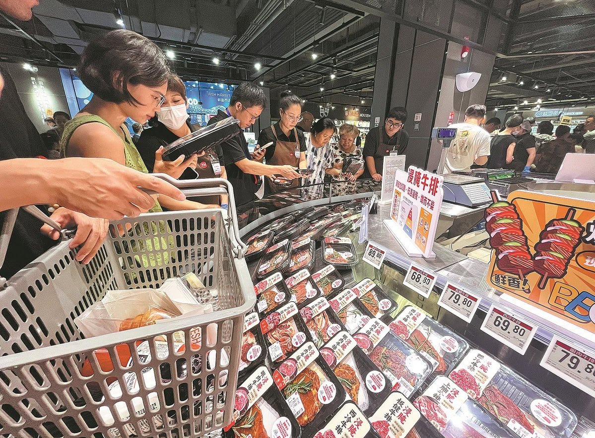 Худалдан авагчид хөл хөдөлгөөн ихтэй супермаркетад савласан хүнсний хөргөгчинд цугларч, чанартай махыг сайтар судалж, сонгож байна. Нэг хүн дэлгүүрийн сагс барьдаг бөгөөд урд талд нь үнэ бүхий тэмдэг харагдана. - Business.MN