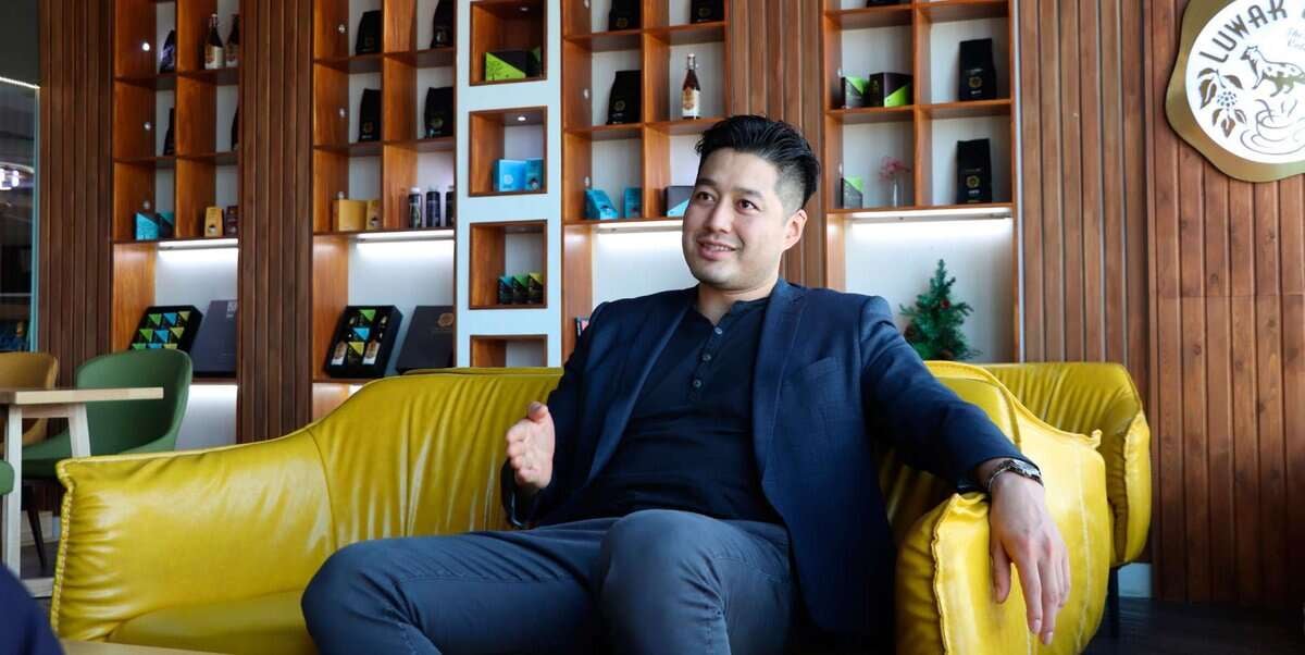 Пиджак өмссөн эр шар буйдан дээр суугаад нэг гараараа дохиж, ард нь модон тавиур бүхий орчин үеийн өрөөнд сууж, амжилттай компанийг хөгжүүлэхэд зайлшгүй шаардлагатай бизнес эрхлэх сэтгэлийг шингээжээ. - Business.MN