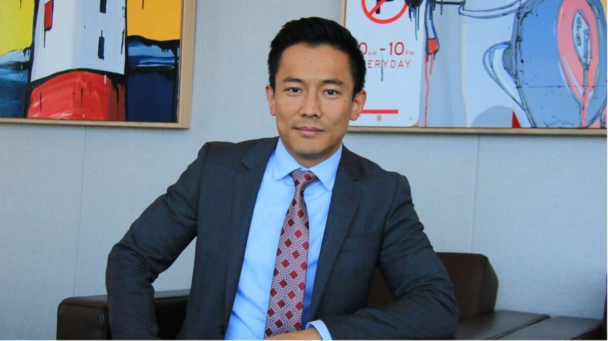 Ханан дээр хийсвэр урлаг бүхий оффист костюм өмссөн бизнес эрхлэгч сууж байна. - Business.MN