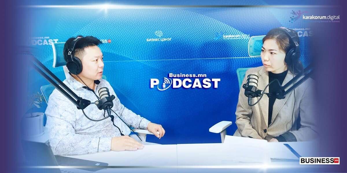 Чихэвч зүүсэн хоёр энтрепренер микрофонтой ширээний ард суугаад "Business.mn Podcast" гэсэн бичигтэй подкаст студид ярилцаж байна. - Business.MN