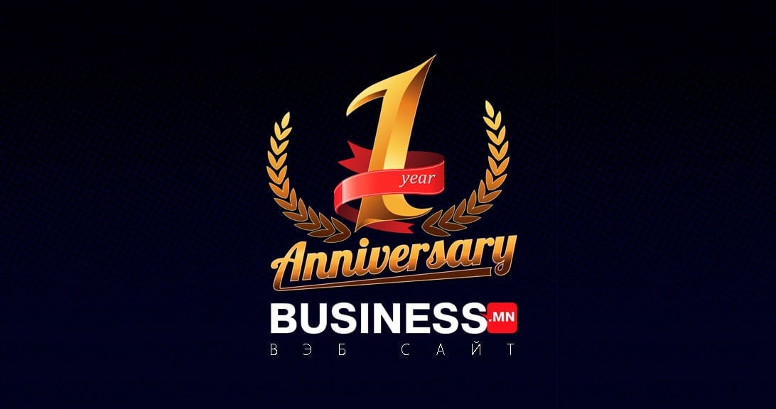 Бараан дэвсгэр дээр "BUSINESS.MN"-ийн дээр "1 жилийн ой" гэсэн бичээс бүхий алтан лаврын цэцэг, успехи компанийг тэмдэглэж байна. - Business.MN