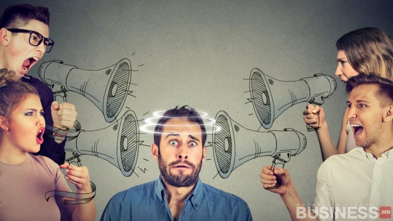 Мегафон барьсан хүмүүсээр хүрээлэгдсэн, чанга дуу чимээг илтгэж буй дууны долгион бүхий шаналж буй хүн бизнесийн ертөнцөд энтрепренерт тулгарч болох эмх замбараагүй сорилтуудыг онцолж байна. - Business.MN