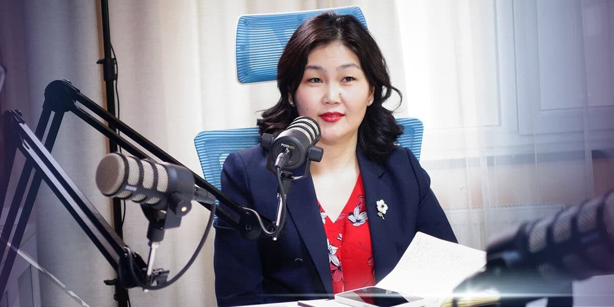 Цэнхэр пиджак, улаан цамц өмссөн, энтрепренер бололтой эмэгтэй цаас барьсаар радиогийн студид микрофоноор ярьж байна. - Business.MN