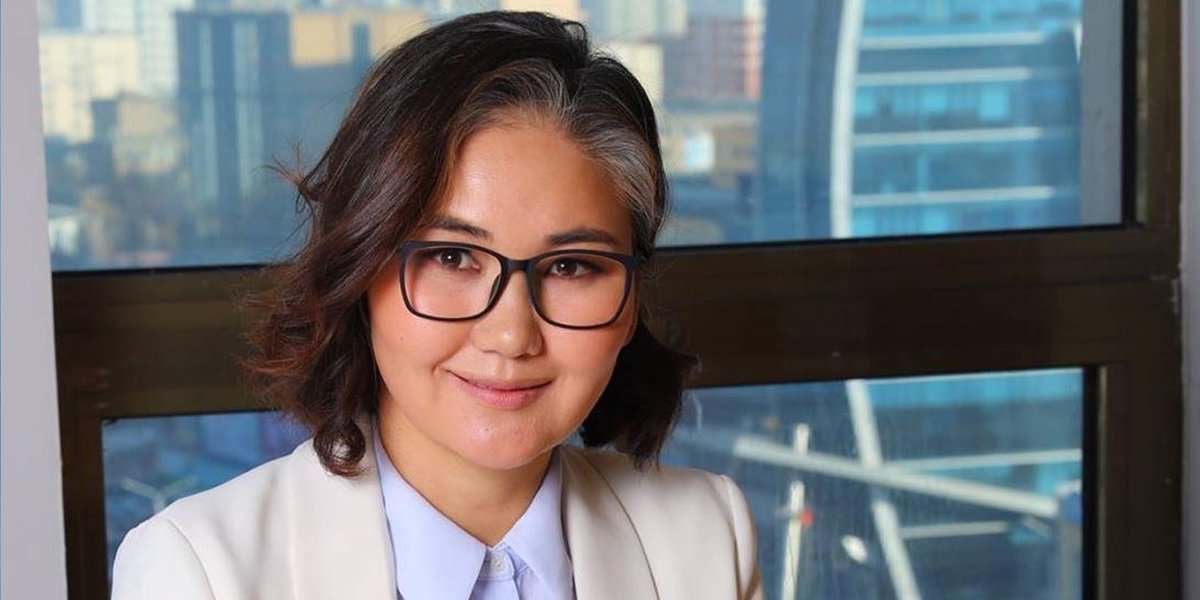 Мөр хүртэл урт үстэй, нүдний шилтэй, цагаан пиджак өмссөн эмэгтэй хотын өнгө үзэмжийг харсан цонхны өмнө инээмсэглэж байгаа нь энтрепренер хүний өөртөө итгэлтэй сүнсийг илэрхийлдэг. - Business.MN