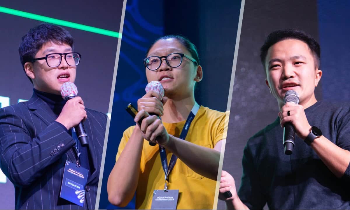 Чуулган дээр үг хэлж байгаа гурван эрэгтэй. Энтрепренер бүр микрофон барьж, хүзүүндээ хурлын тэмдэг зүүдэг. Тэд өөр өөр хувцастай: нэг нь костюмтай, нөгөө нь шар цамцтай, гурав дахь нь хар цамцтай. - Business.MN