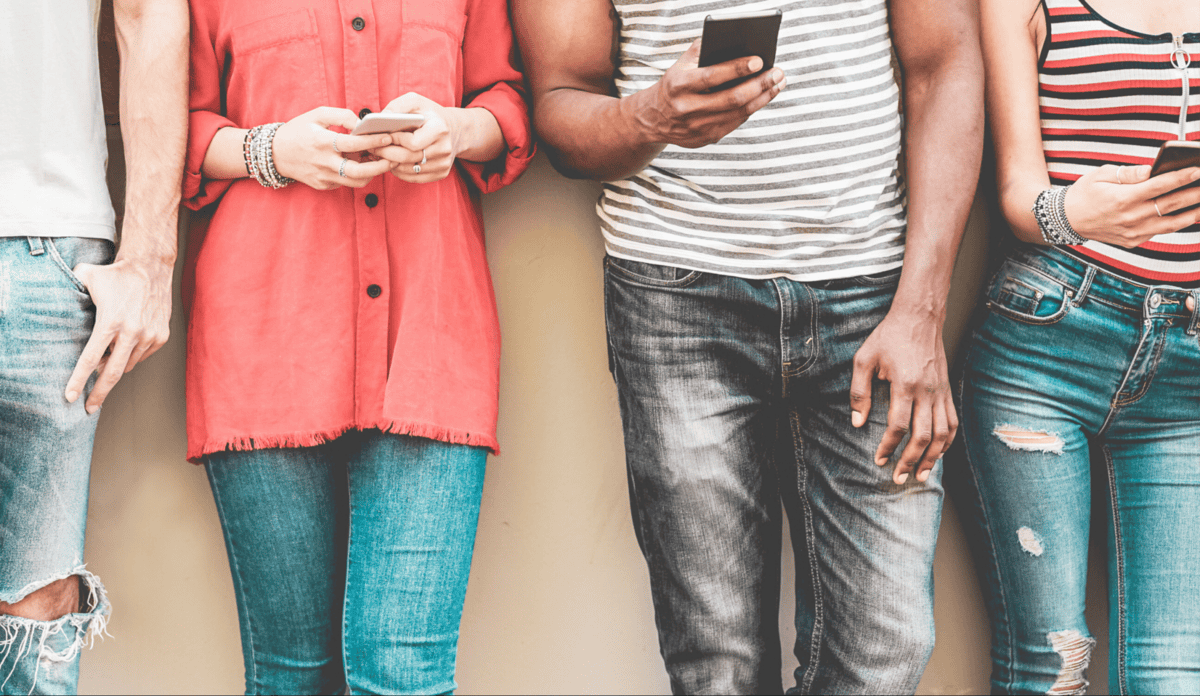 Дөрвөн хүн шаргал хананы дэргэд зэрэгцэн зогсч, бүгд ухаалаг утас барьсан байна. Тэд жинсэн өмд, янз бүрийн цамц өмссөн нь орчин үеийн бизнес эрхлэгчдийн тайван байдлыг илэрхийлдэг. Тэдний царайг харуулахгүй, зөвхөн их биендээ анхаарлаа хандуулдаг. - Business.MN