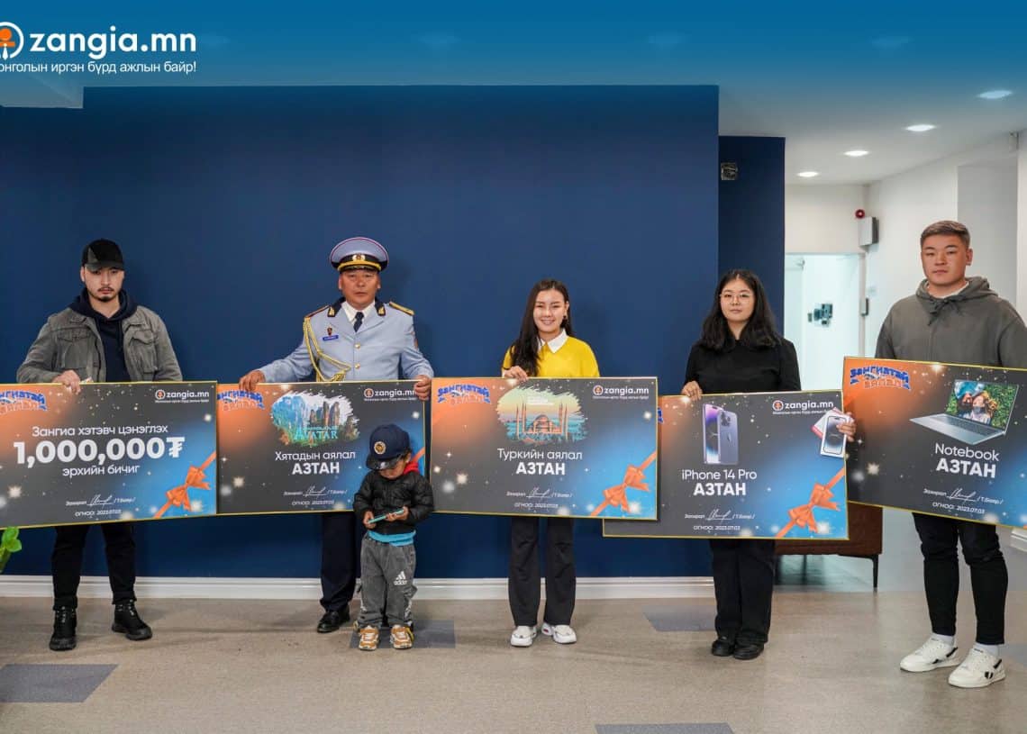 Зургаан энтрепренерүүд дараалан том шагналын гэрчилгээг барьсаар, нэг хүүхэд урд өвдөг сөгдөн зогсож байна. Сертификатуудад бичвэр, электрон бараа, бэлэн мөнгө зэрэг шагналын зураг, зүүн дээд буланд Zangia.mn логог байрлуулсан байна. - Business.MN