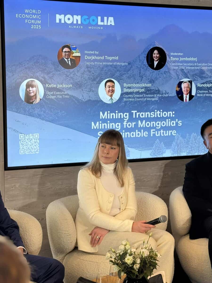 A panel discussion at the World Economic Forum 2025. A woman in a white suit sits in the center, surrounded by others. The backdrop reads "Mining Transition: Mining for Mongolia’s Sustainable Future" with portraits and names of speakers above.