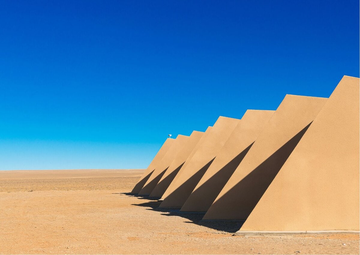 Цэлмэг цэлмэг хөх тэнгэрийн дор орчин үеийн, гурвалжин шаргал байгууламжуудын эгнээ зогсож байгаа нь тогтвортой аялал жуулчлалын архитектурын жишээ бөгөөд тогтвортой байдлыг гайхалтай геометрийн дизайнтай хослуулсан юм. - Business.MN