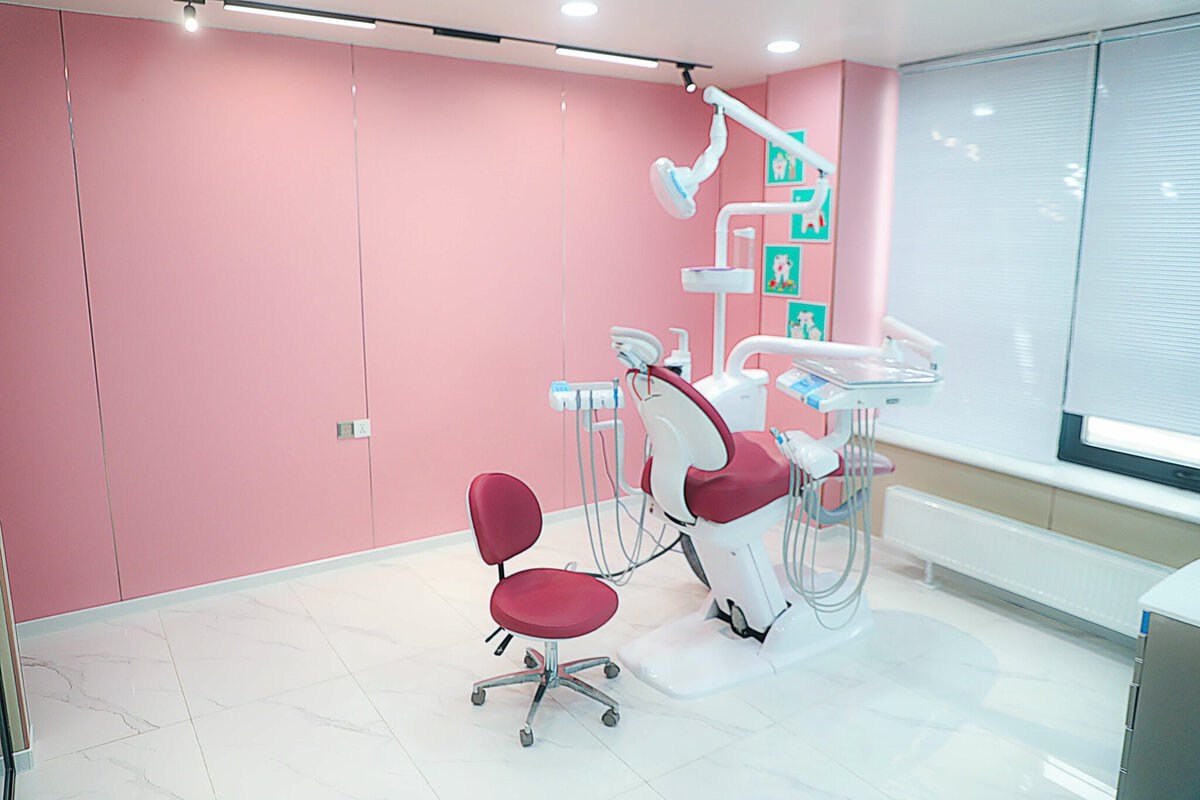 Ягаан ханатай орчин үеийн шүдний эмнэлгийн клиникийн өрөө, хавсаргасан тоног төхөөрөмж бүхий шүдний сандал, тохирох ягаан сандал, ханан дээрх хүрээтэй уран бүтээл, цагаан плита шал, том цонхнууд нь наалттай. - Business.MN