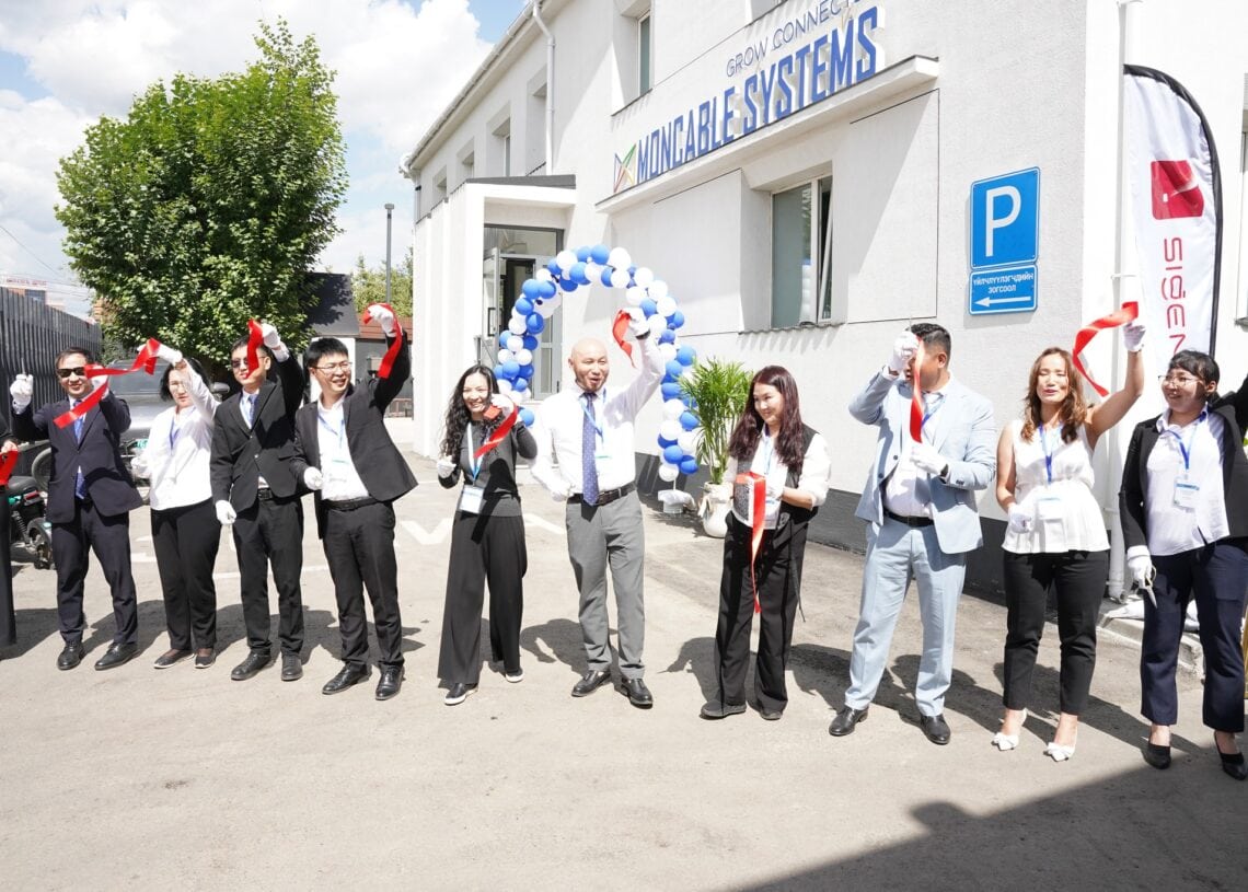 Ногоон ирээдүйн төлөөх амлалтаа илэрхийлж, ногоон барилгын өмнө зогсож буй хэсэг хүмүүс. - Business.MN