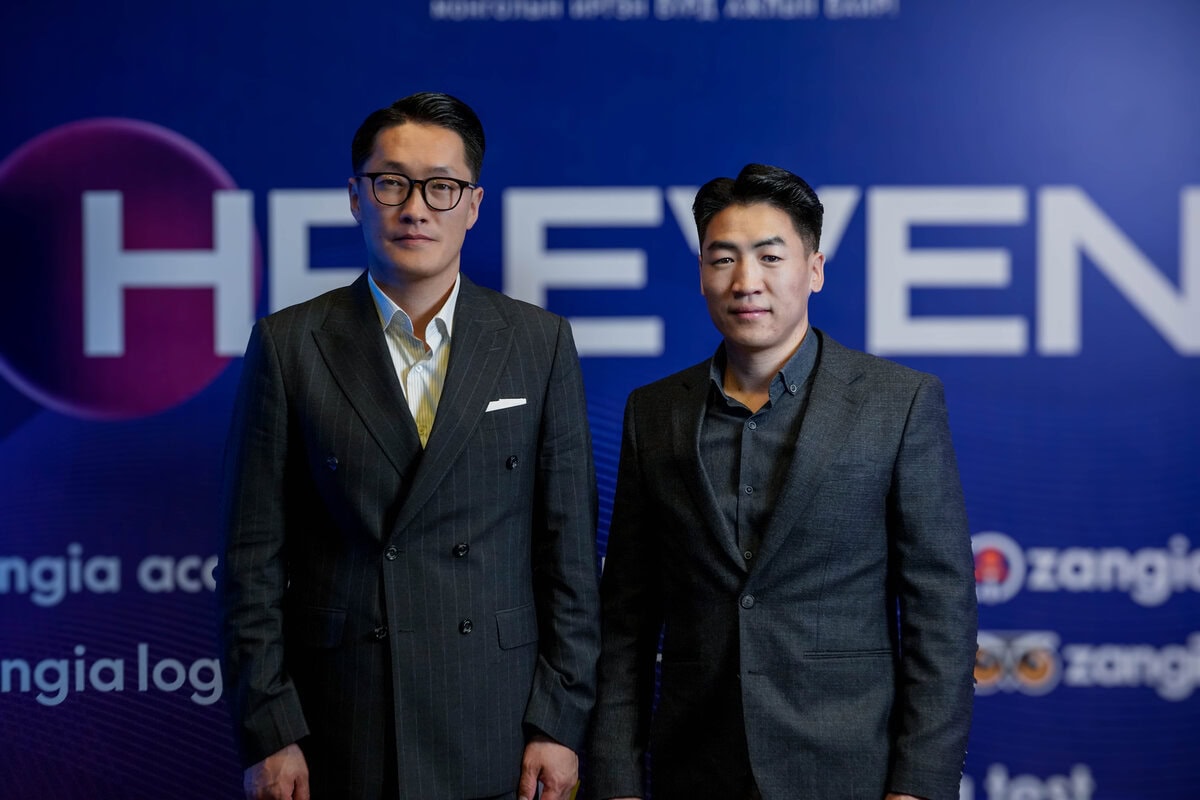 Харанхуй костюмтай хоёр эрэгтэй том, хэсэгчлэн харагдахуйц бичвэр, хүний нөөцийн лого бүхий цэнхэр дэвсгэрийн өмнө зэрэгцэн зогсож байна. Хоёулаа төвийг сахисан илэрхийлэлтэйгээр камер руу харж байна. - Business.MN