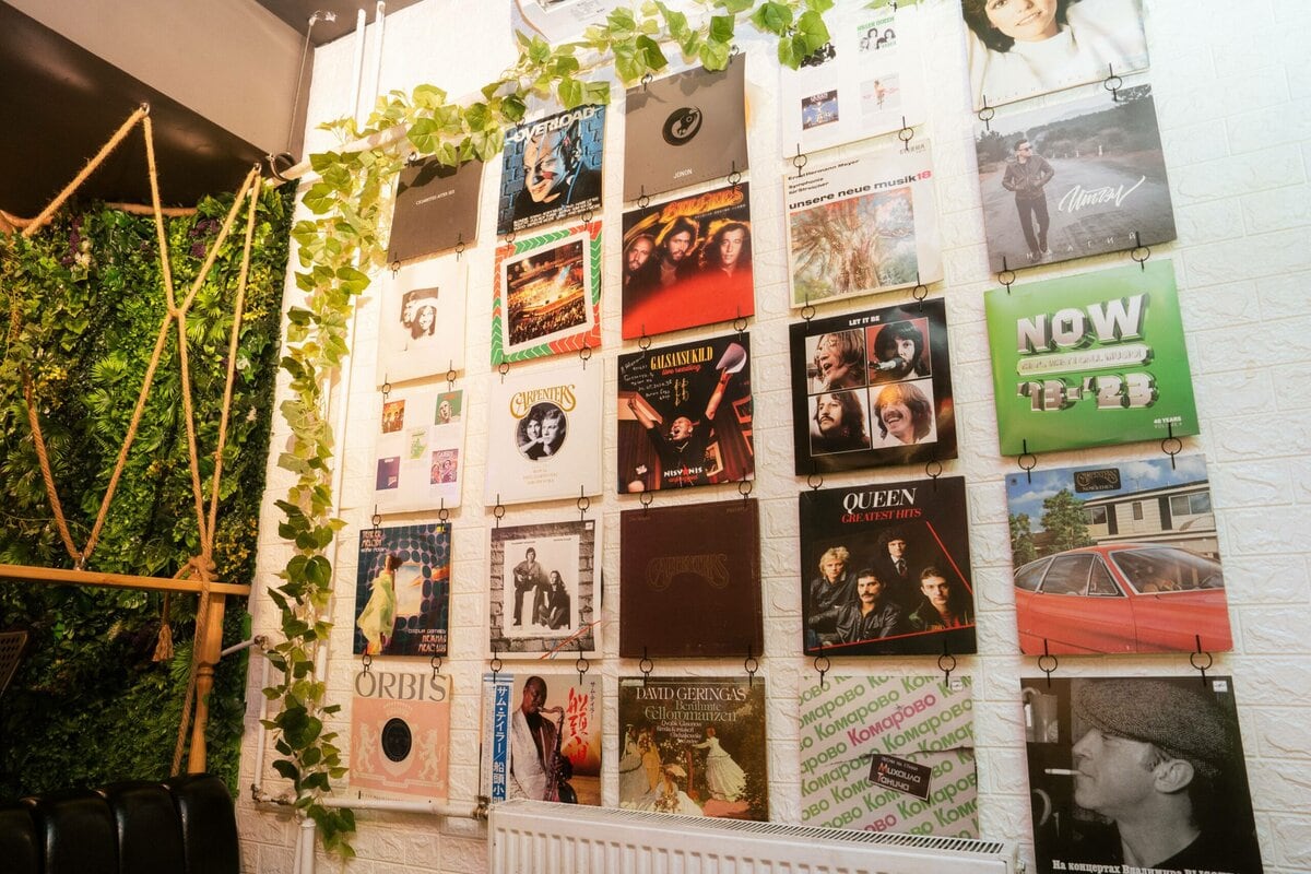 Улаанбаатар дахь Ketomo Cafe Wine-ийн ханыг винил пянзны хавтас, цомгийн урлагаар чимэглэсэн нь өлгөөтэй ногоон ургамлаар хүрээлэгдсэн нь кафед дурлагсдад зориулсан чимэг, тухтай уур амьсгалыг бүрдүүлдэг. - Business.MN