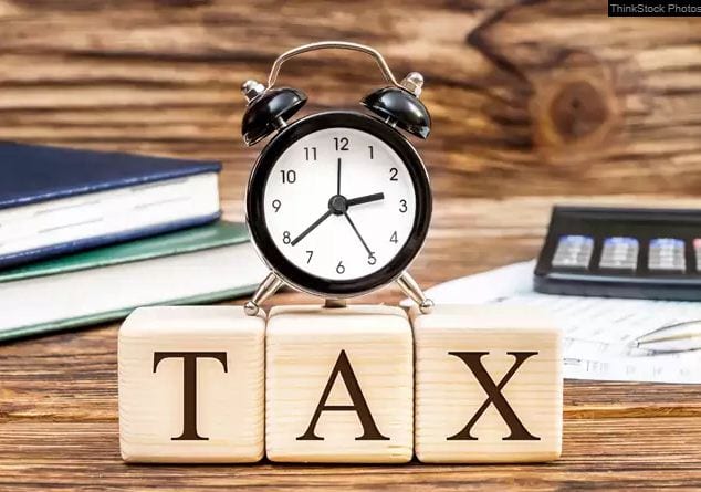 Сэрүүлгийн цаг нь "ТАТВАР" гэж бичсэн модон блок дээр сууж, модон гадаргуу дээр цаана нь ном, тооны машинтай. - Business.MN