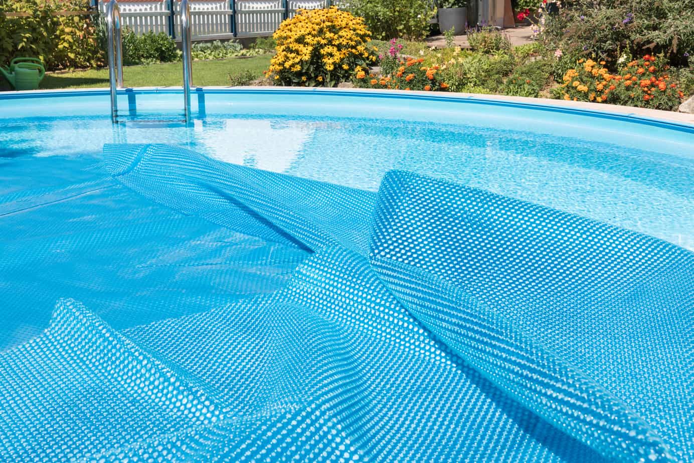 A pool with a cover partially covering the surface of the water.