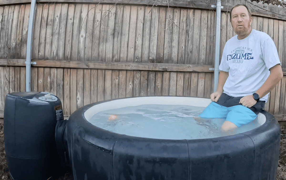Man sitting on the edge of the Softub. Legs wading in the heated water.