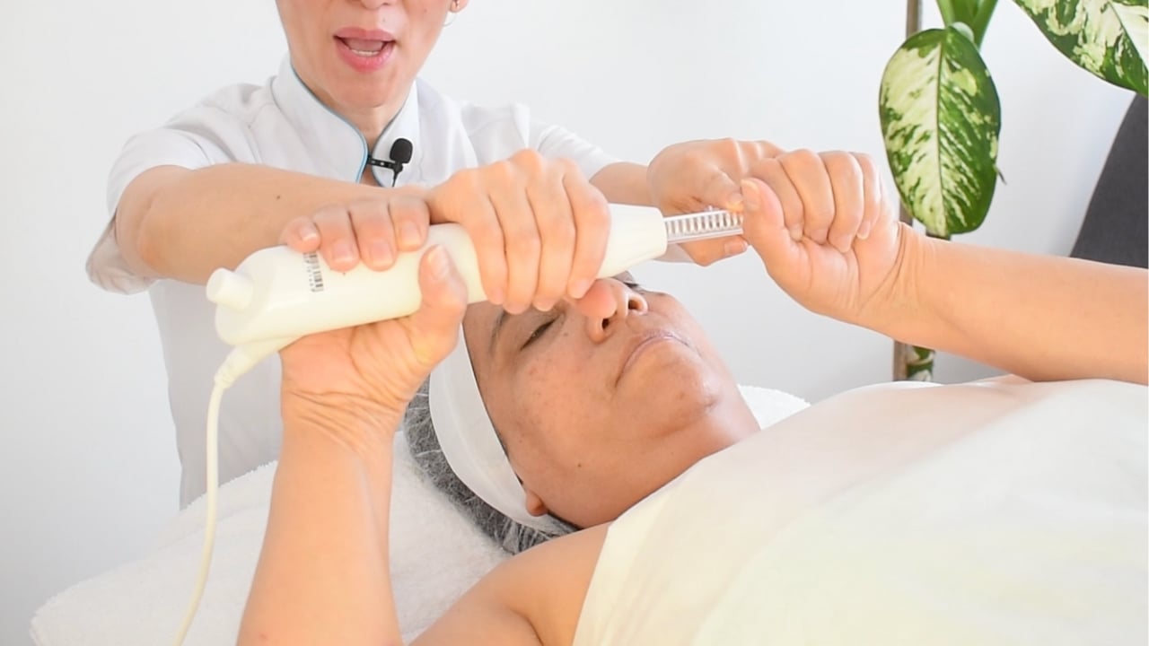 Clienta sujetando el electrodo de fulguración correctamente antes de iniciar el masaje.