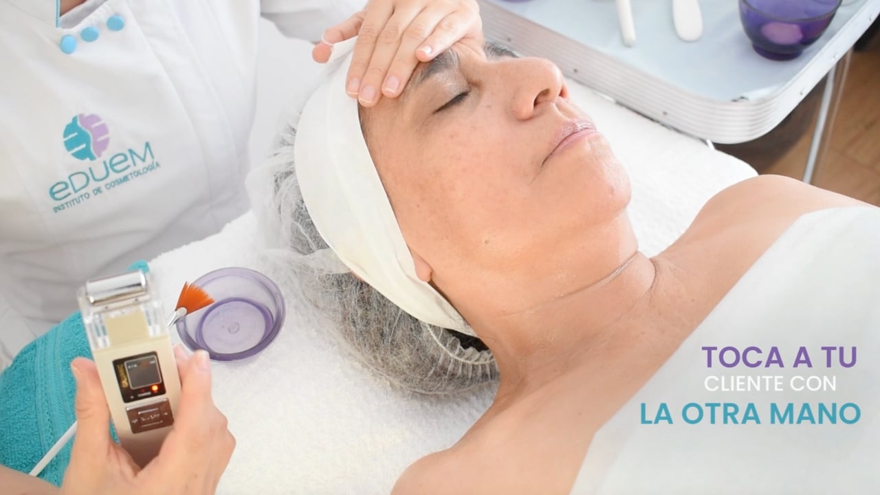 Esteticista profesional aplicando tratamiento con corriente galvánica.