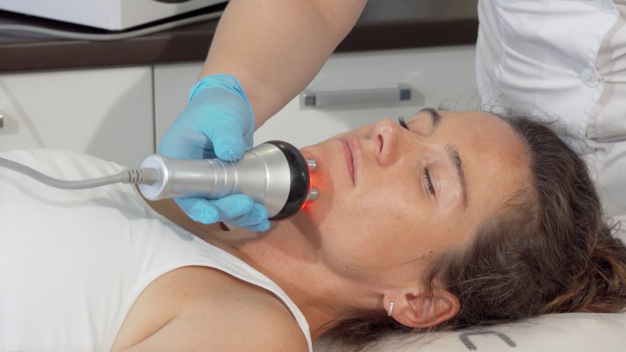 Mujer recibiendo tratamiento de ultrasonido facial para mejorar la piel madura.