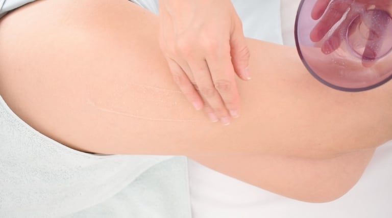 Preparación de la piel con exfoliante antes del tratamiento anticelulitis.