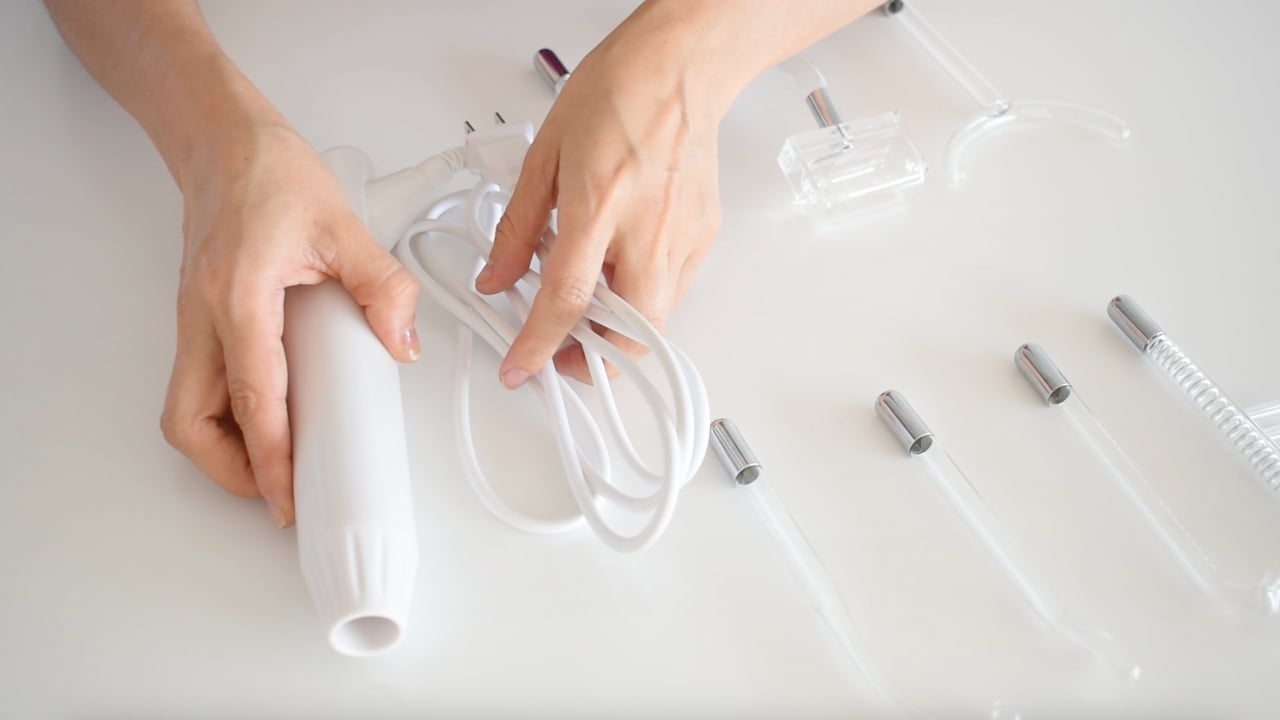 Aparato de alta frecuencia estética con electrodos para tratamientos faciales y corporales.