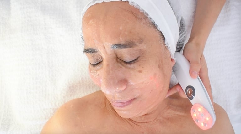 Cosmetóloga aplicando microestimulación facial, resaltando los beneficios del tratamiento para mejorar el tono de la piel.