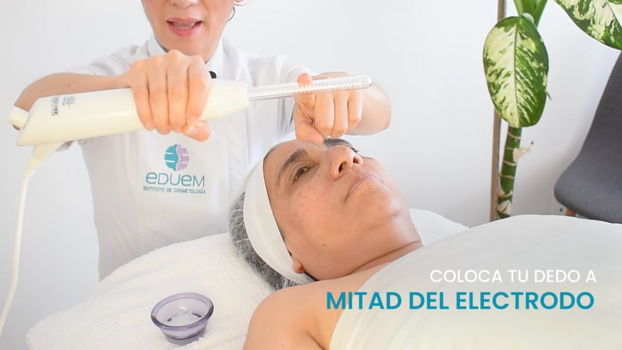 Profesional ajustando el electrodo de fulguración en el maneral del aparato de alta frecuencia.