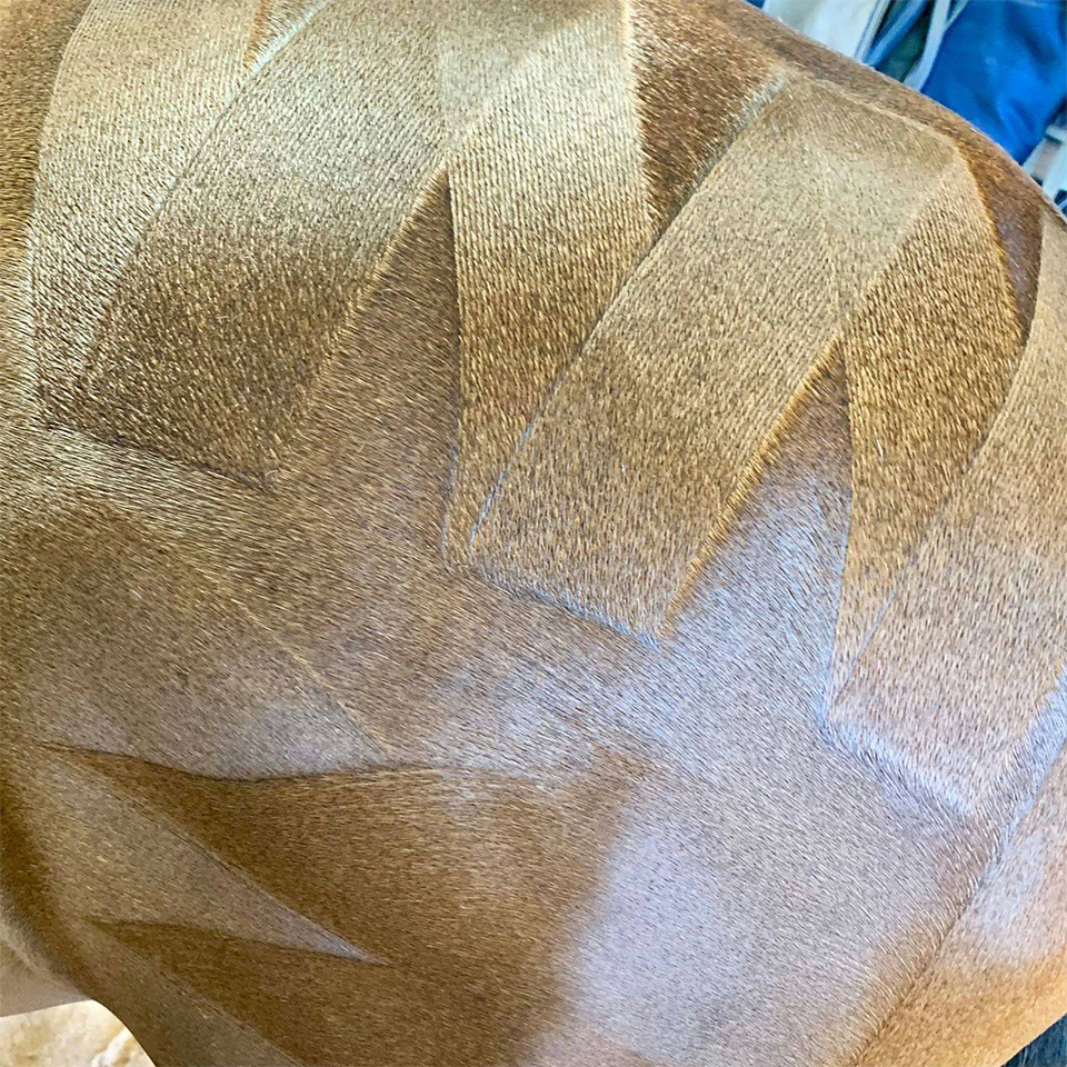 A close up of an NTR Ultimate Marker Comb brown leather chair.